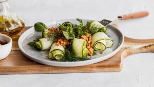 Delicious zucchini and lentil salad garnished with herbs on a wooden board, perfect for healthy eating.